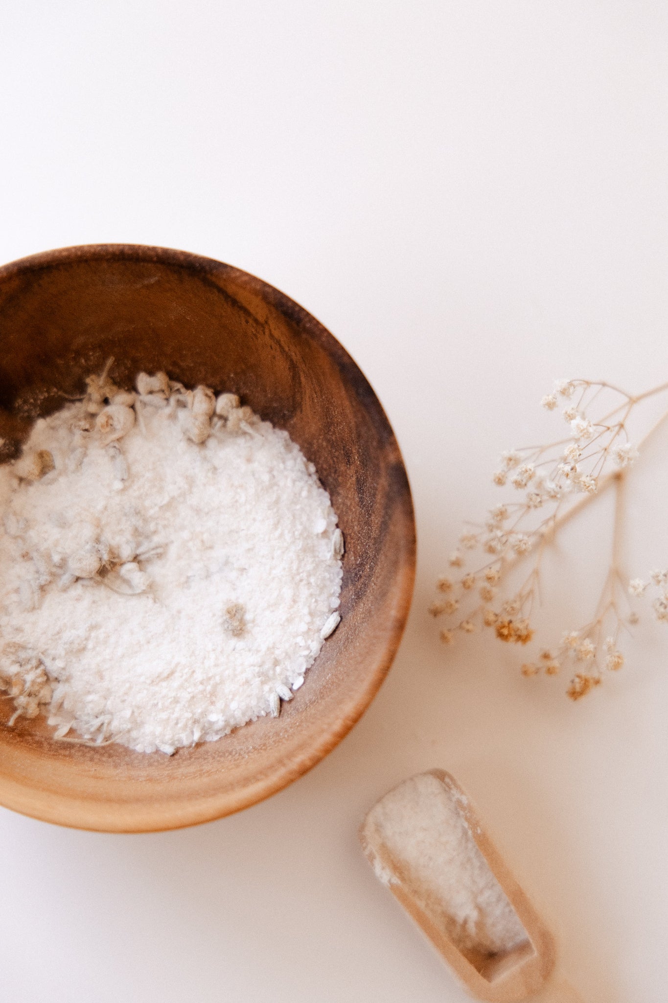Wooden bowl with Generate Kind Co. Bath Soak on a light background