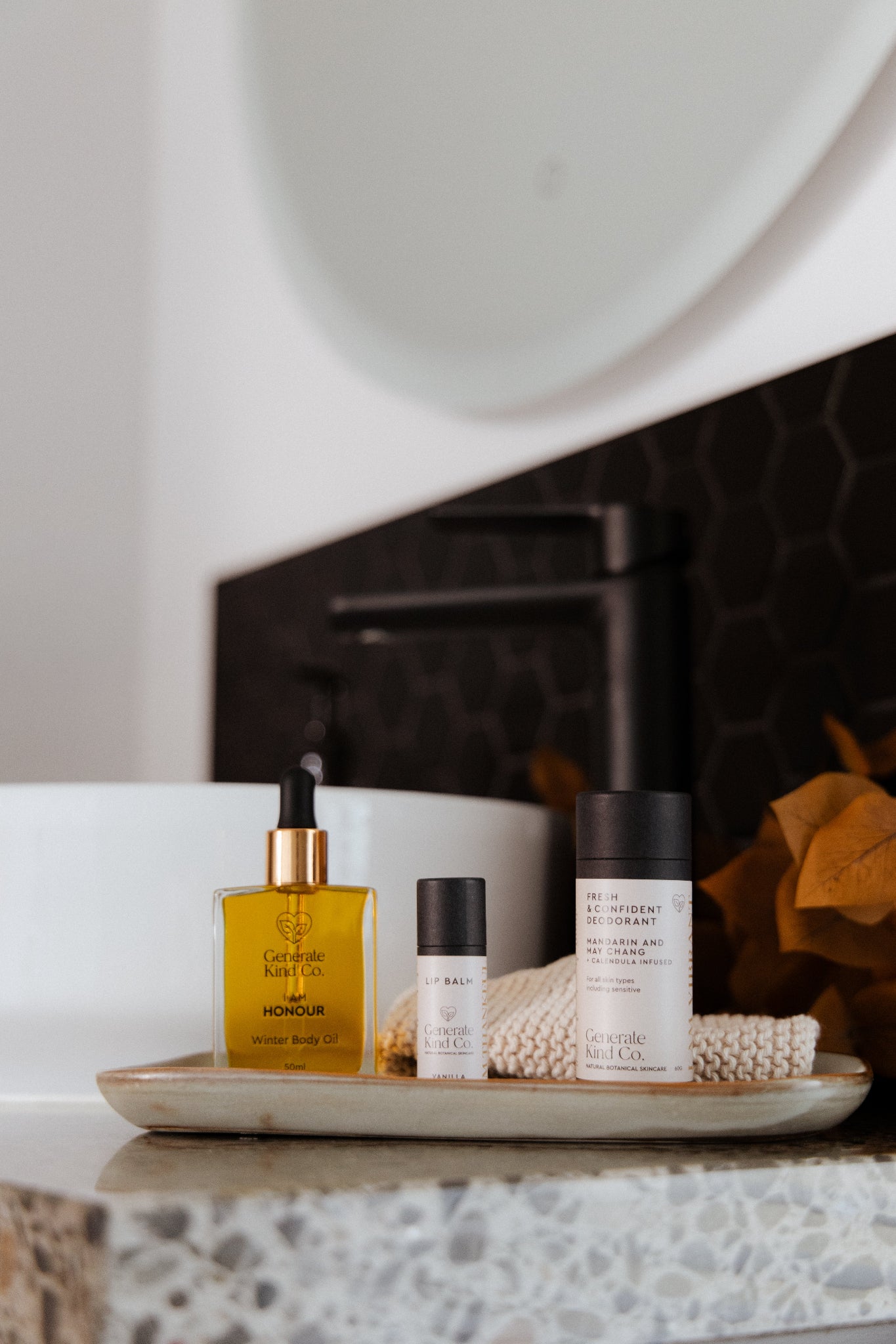 Generate Kind Co. Body care essenatils Lip Balm, natural deodorant and Winter Body Oil on tray in bathroom