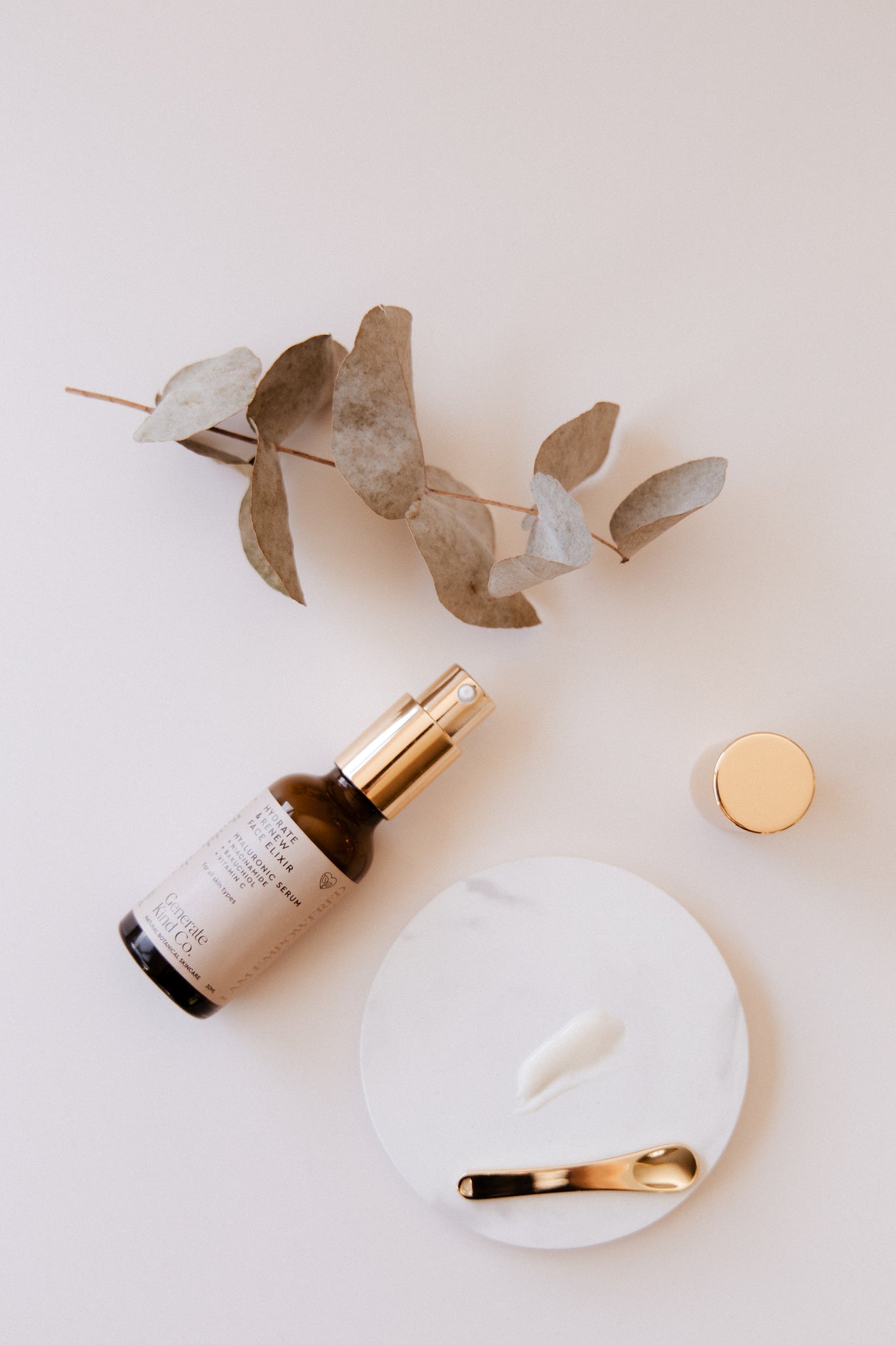Face Elixir Hyaluronic Serum and eucalyptus branch on a light background