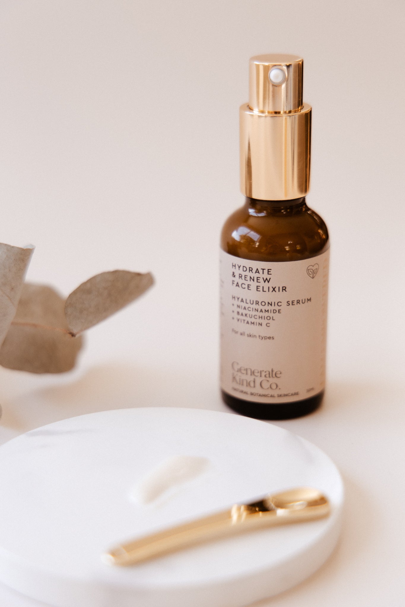 Face Elixir Hyaluronic Serum and eucalyptus branch on a light background
