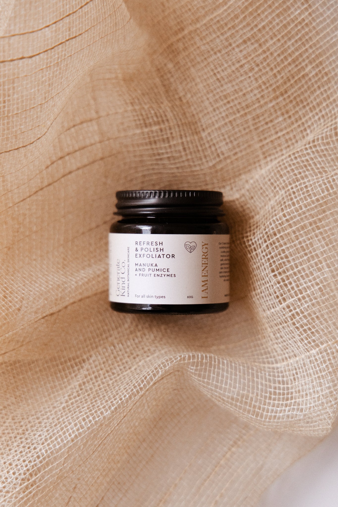 Jar of Generate Kind Co exfoliator skincare product on a textured fabric background