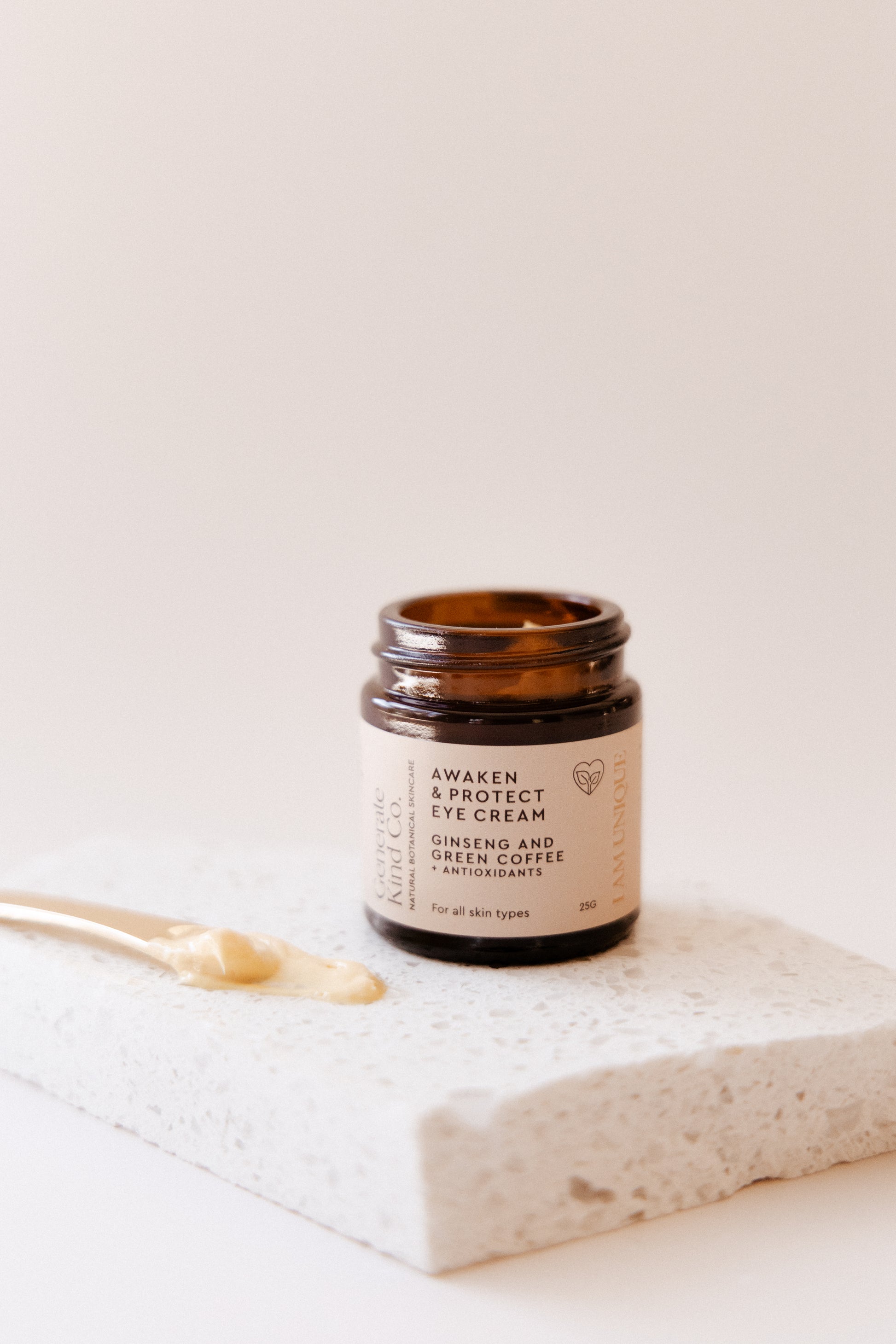 Eye cream jar with a gold applicator on marble 