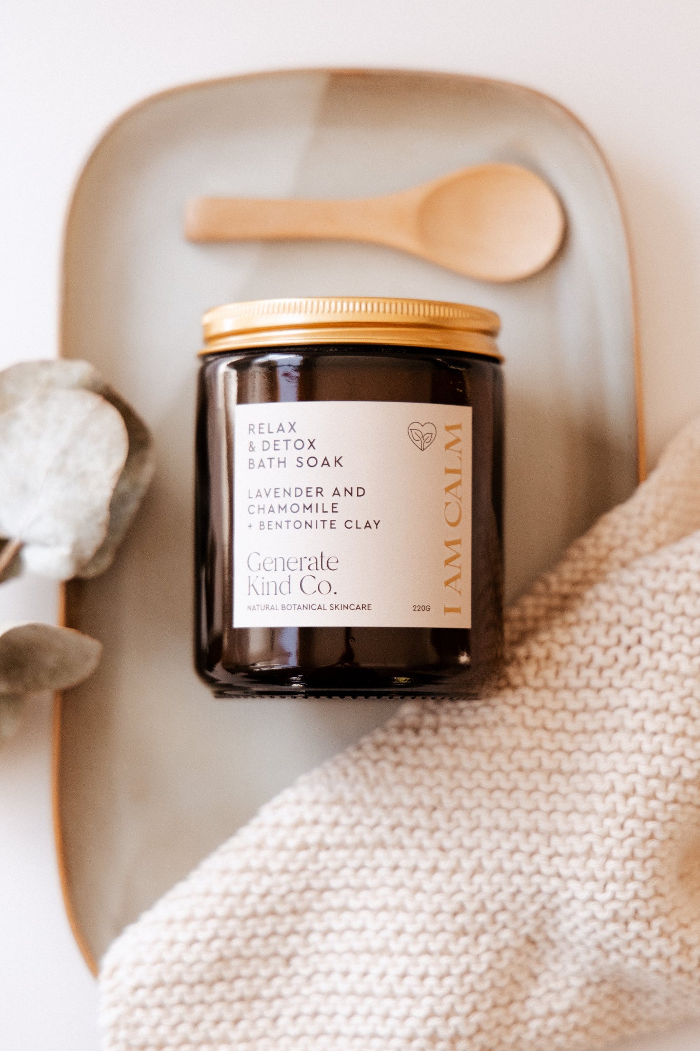 Jar of Generate Kind Co. bath soak with a wooden spoon