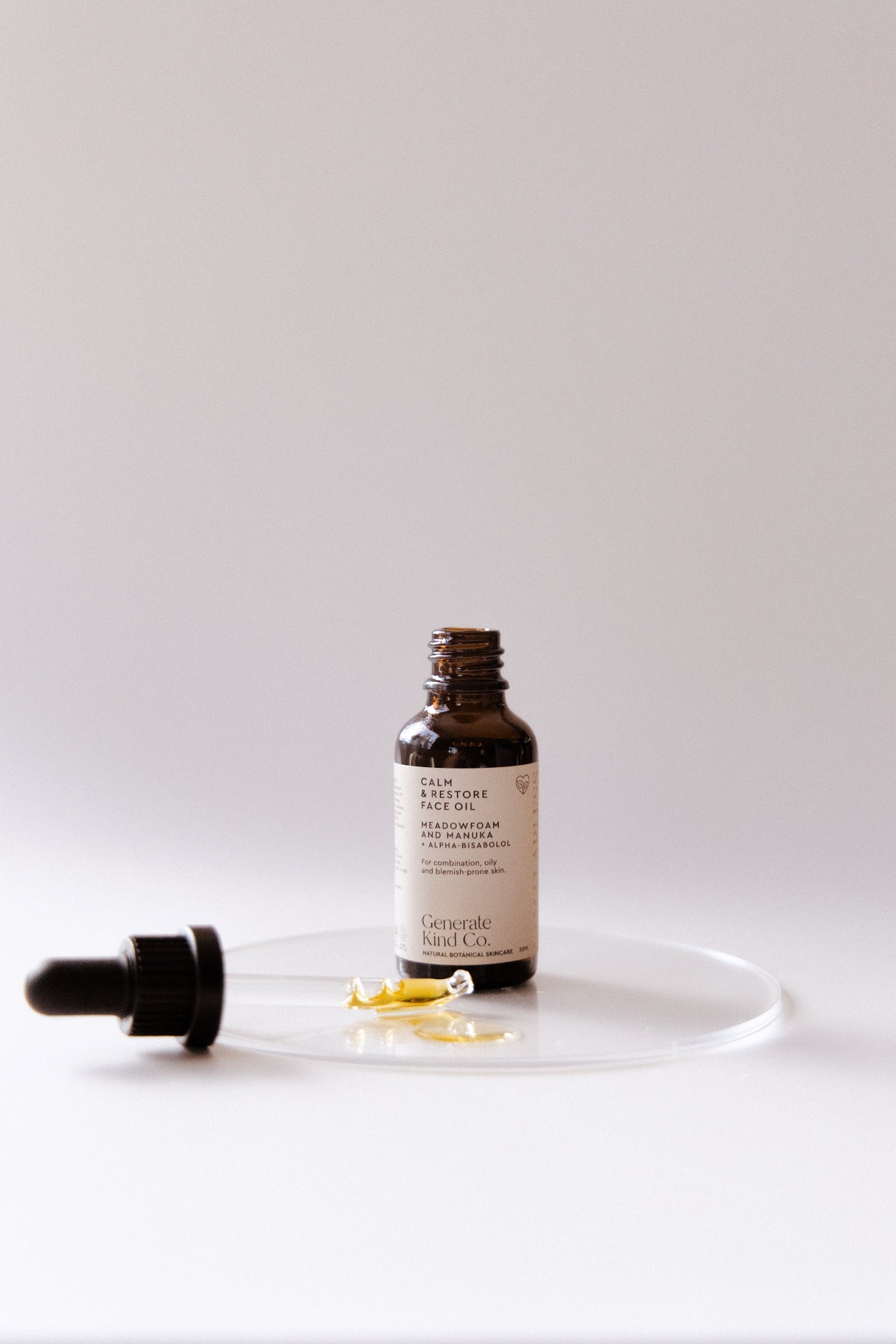 Bottle of Calm restore Face oil with dropper on a white background