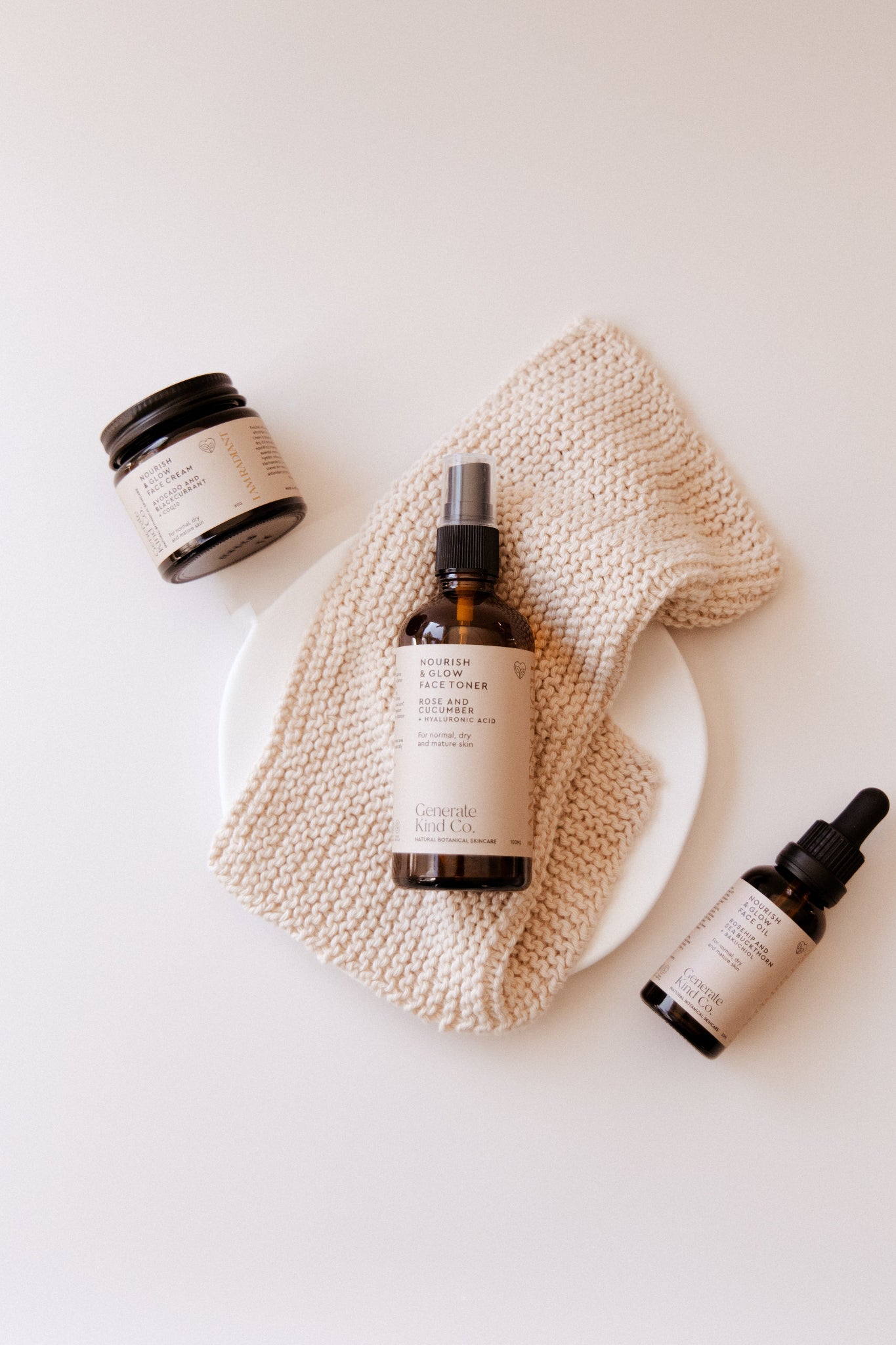 Generate Kind CO Nourish & Glow products on a textured cloth with a white background.