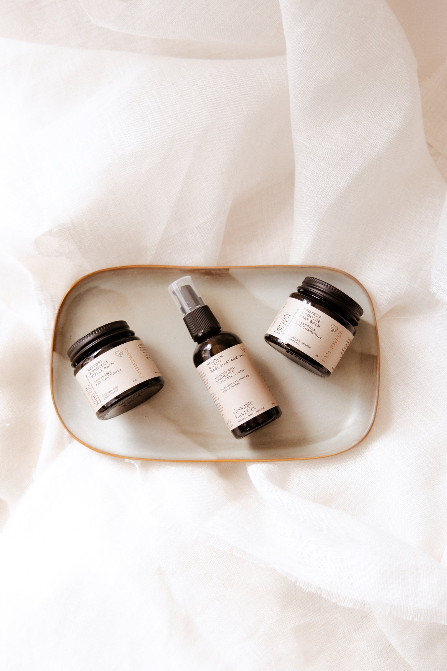 Mama and Baby skincare products on a  tray with a white fabric background