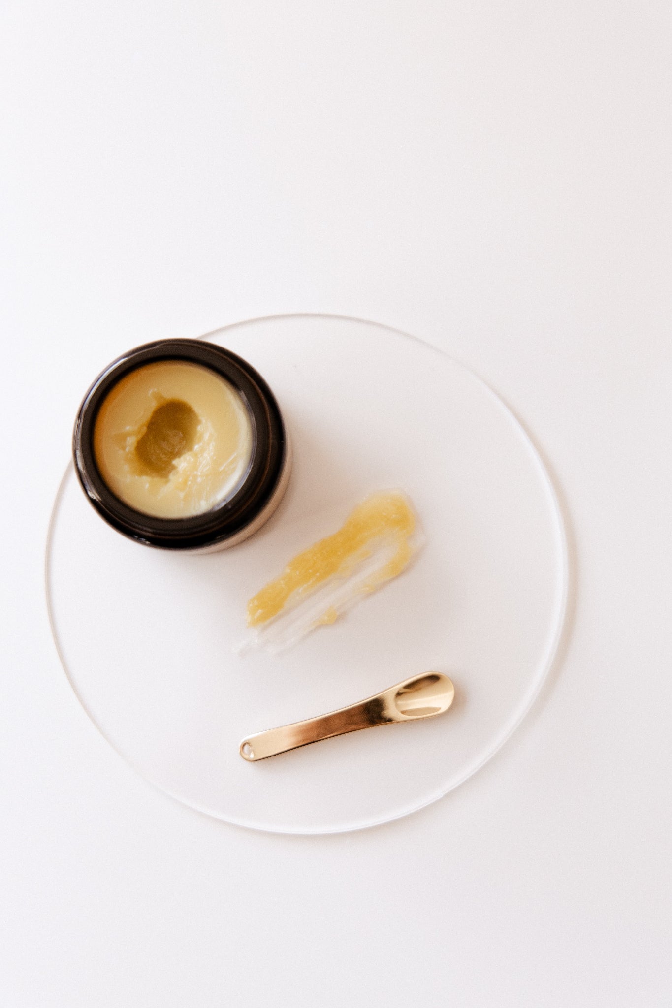 Restore & Protect Nipple Balm with a spoon on a white plate on a white background