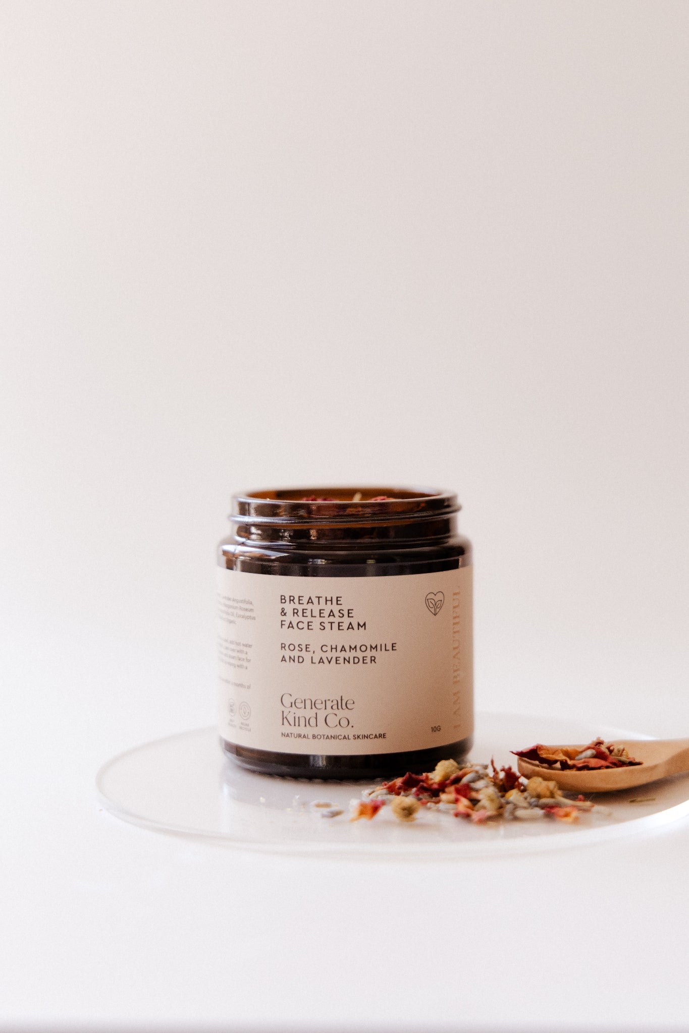 Jar of Botanical Face Steam with a wooden spoon on a white background
