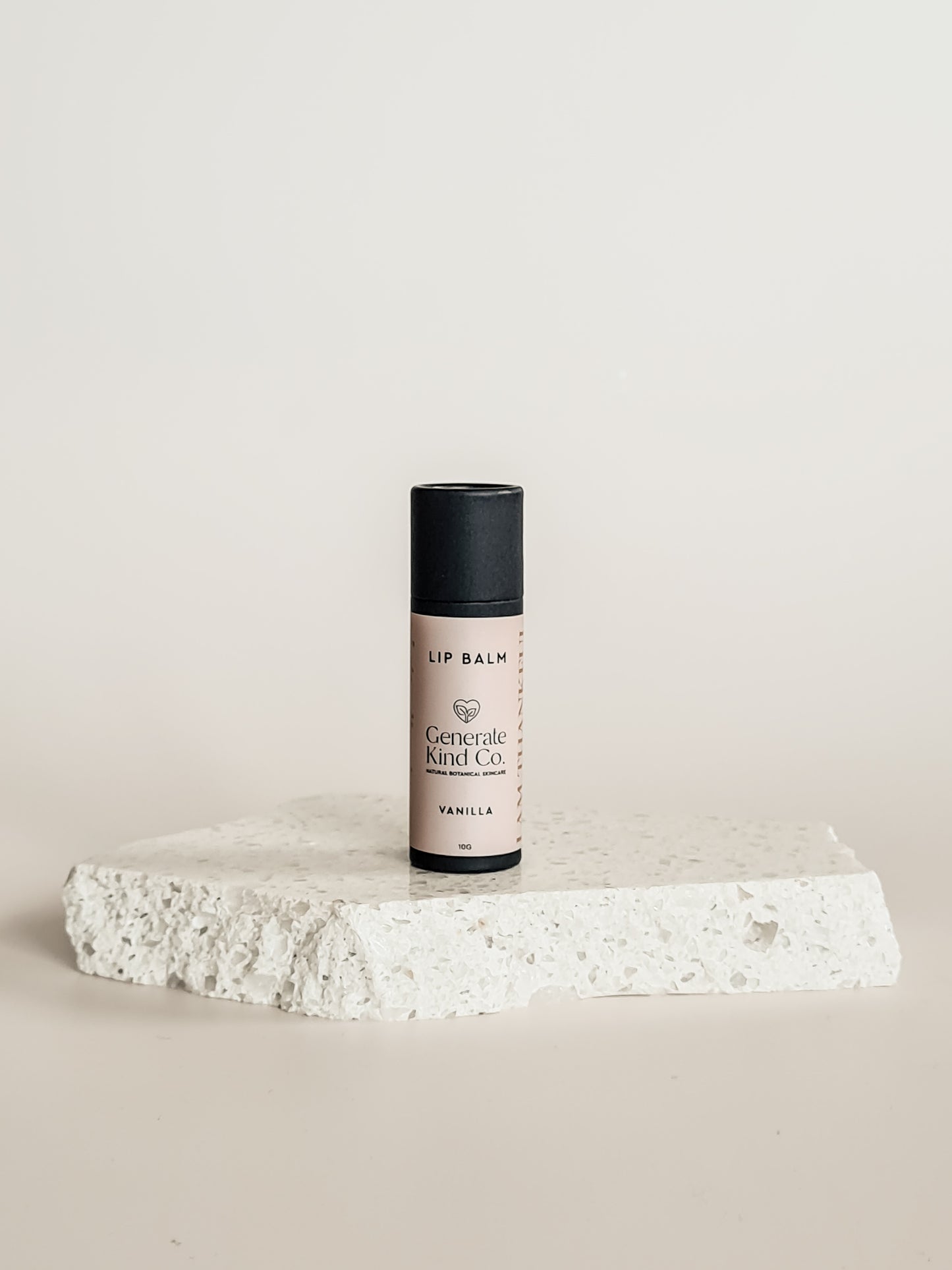 Lip balm on a stone surface with a neutral background