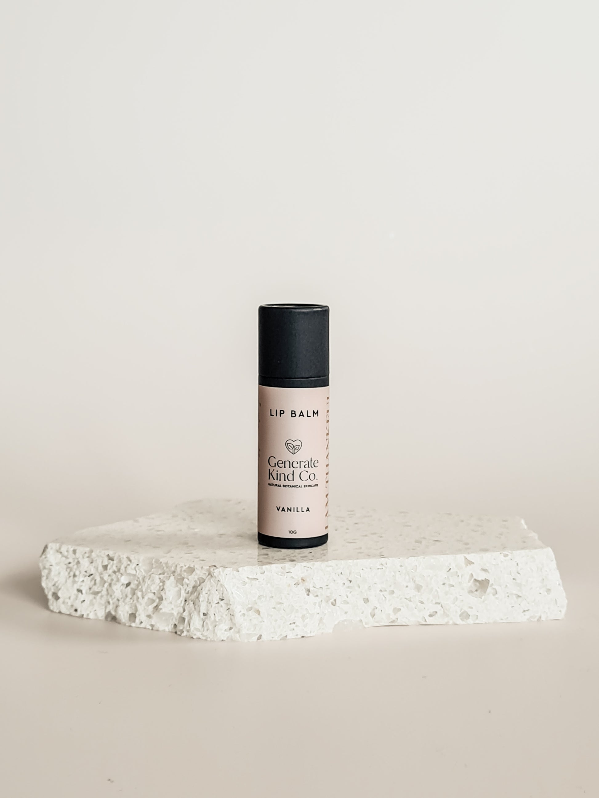 Lip balm on a stone surface with a neutral background